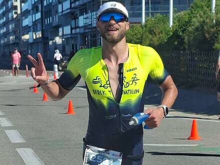 Triathlète en course à pied, souriant, signe de la main