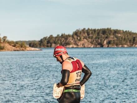 Athlète en combinaison face à un lac, dossard 172, swimrun