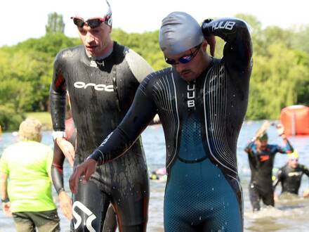 Deux nageurs en combinaison sortant de l'eau après la natation d'un triathlon