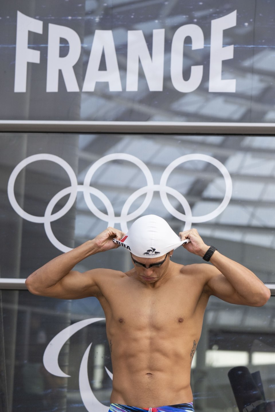 Amazigh Yebba ajustant son bonnet devant les anneaux olympiques
